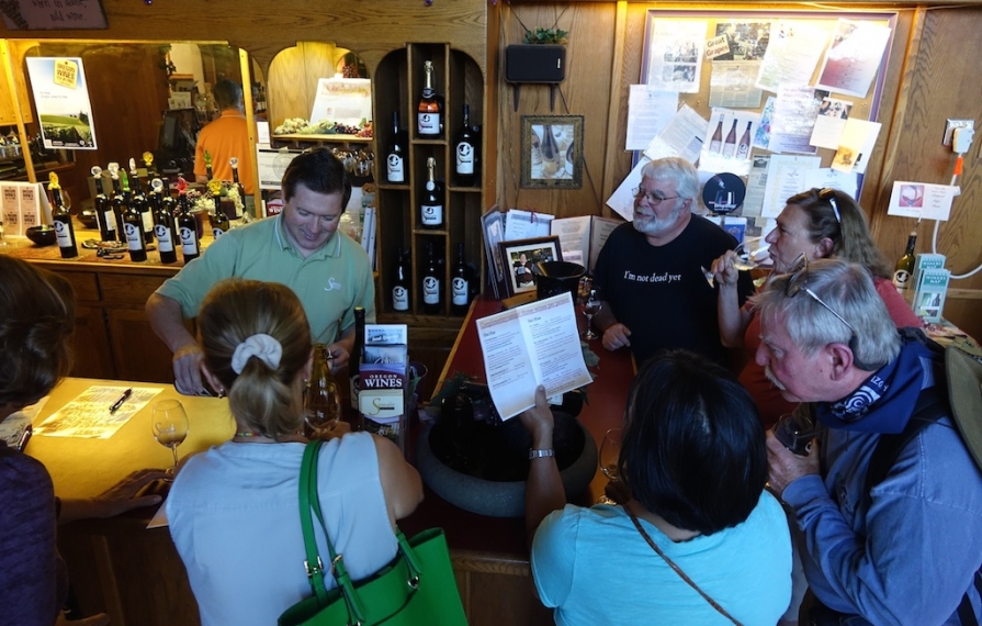 A group gathered at a bar for a wine tasting.